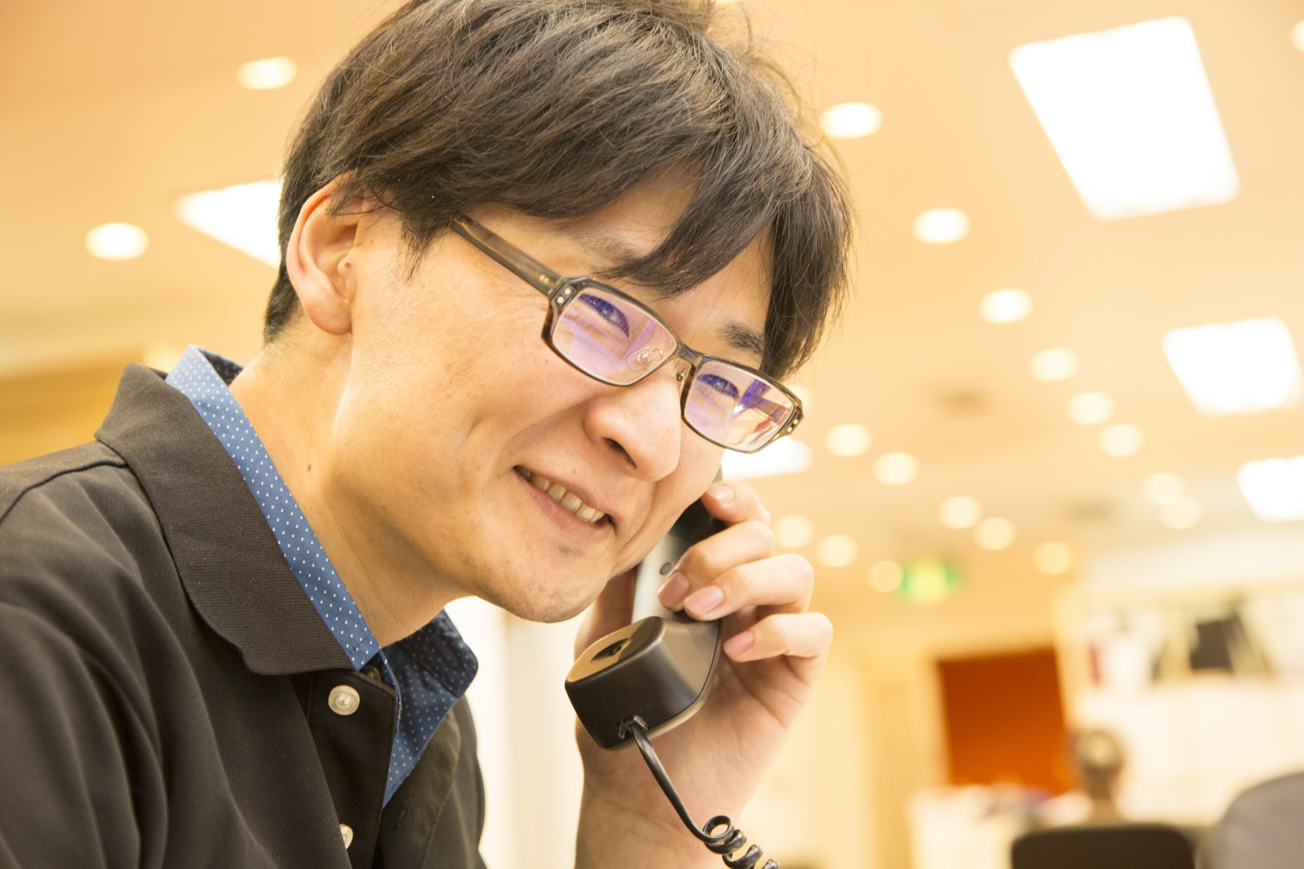 電話で話しながら対応するスタッフ