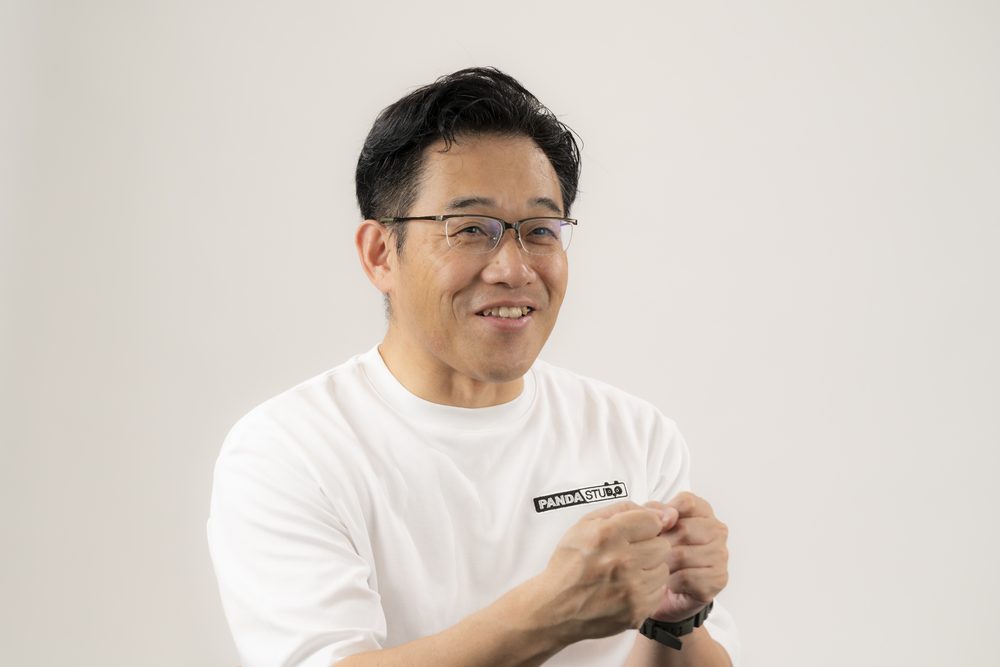 手を組んで話す藤本秀基さん
