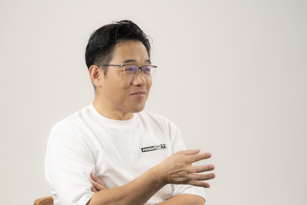 両手を前に出して話す藤本秀基さん